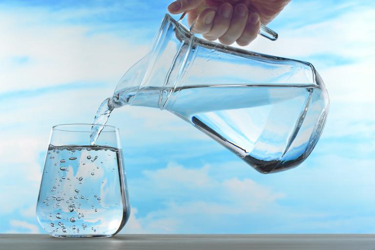 A pitcher of water pouring out into a glass.