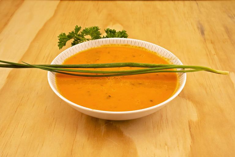 a bowl of tomato soup with fresh chives